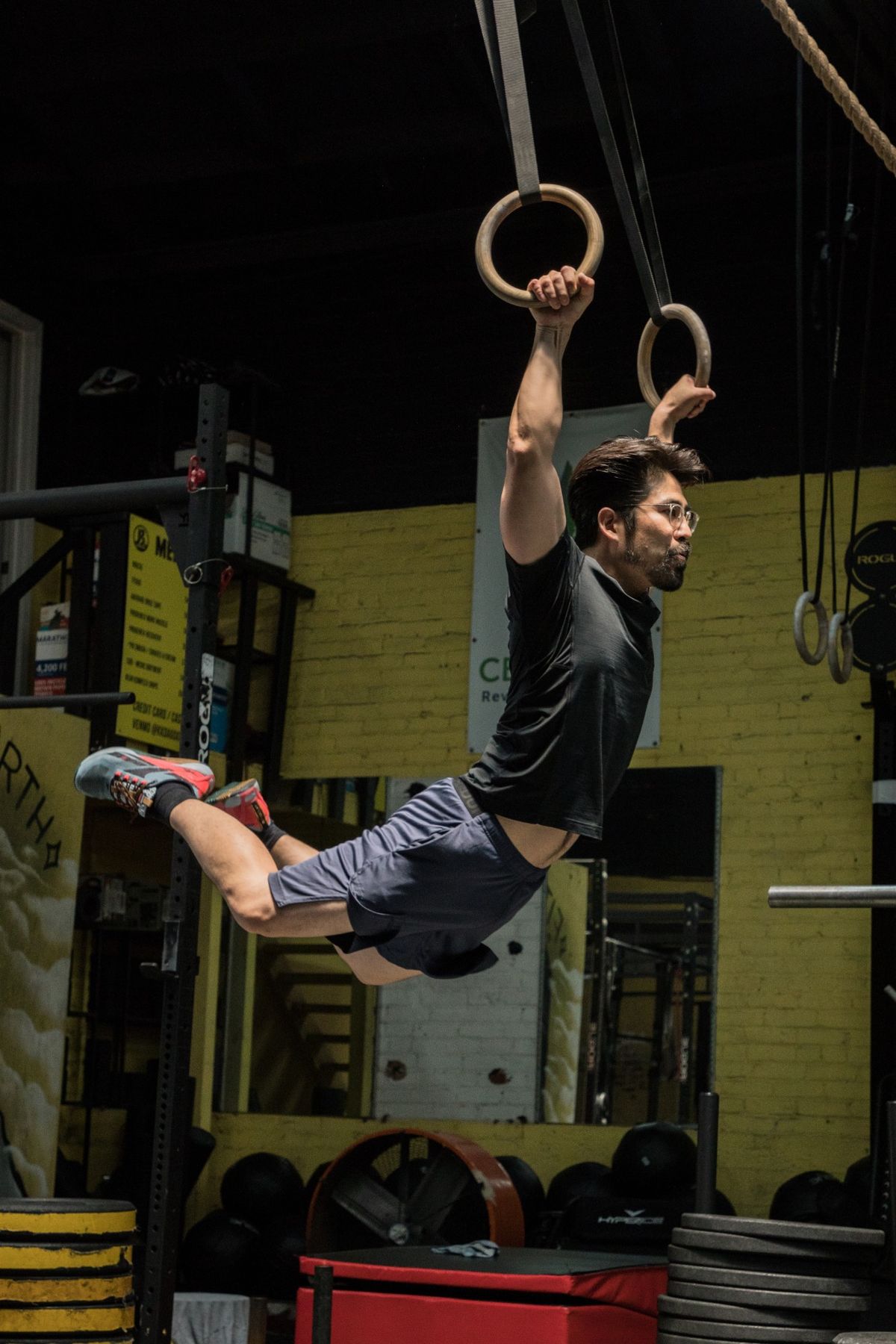Member mid-swing on the gymnastic rings during a class at K2 in Koreatown